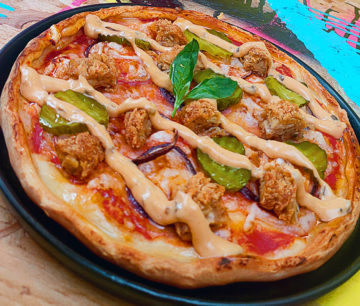 Cook-at-home Loaded Pizza with Crispy Fried Jackfruit patty pieces, pickles, red onion and Biff's Burger Sauce